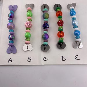 Beaded cell phone grip strap for cell phone case with adhesive grips to secure. 5” long
