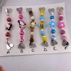 Beaded cell phone, IPad or kindle grip strap holder with various silicone focal bead, heart shaped adhesive grips for back. 7”