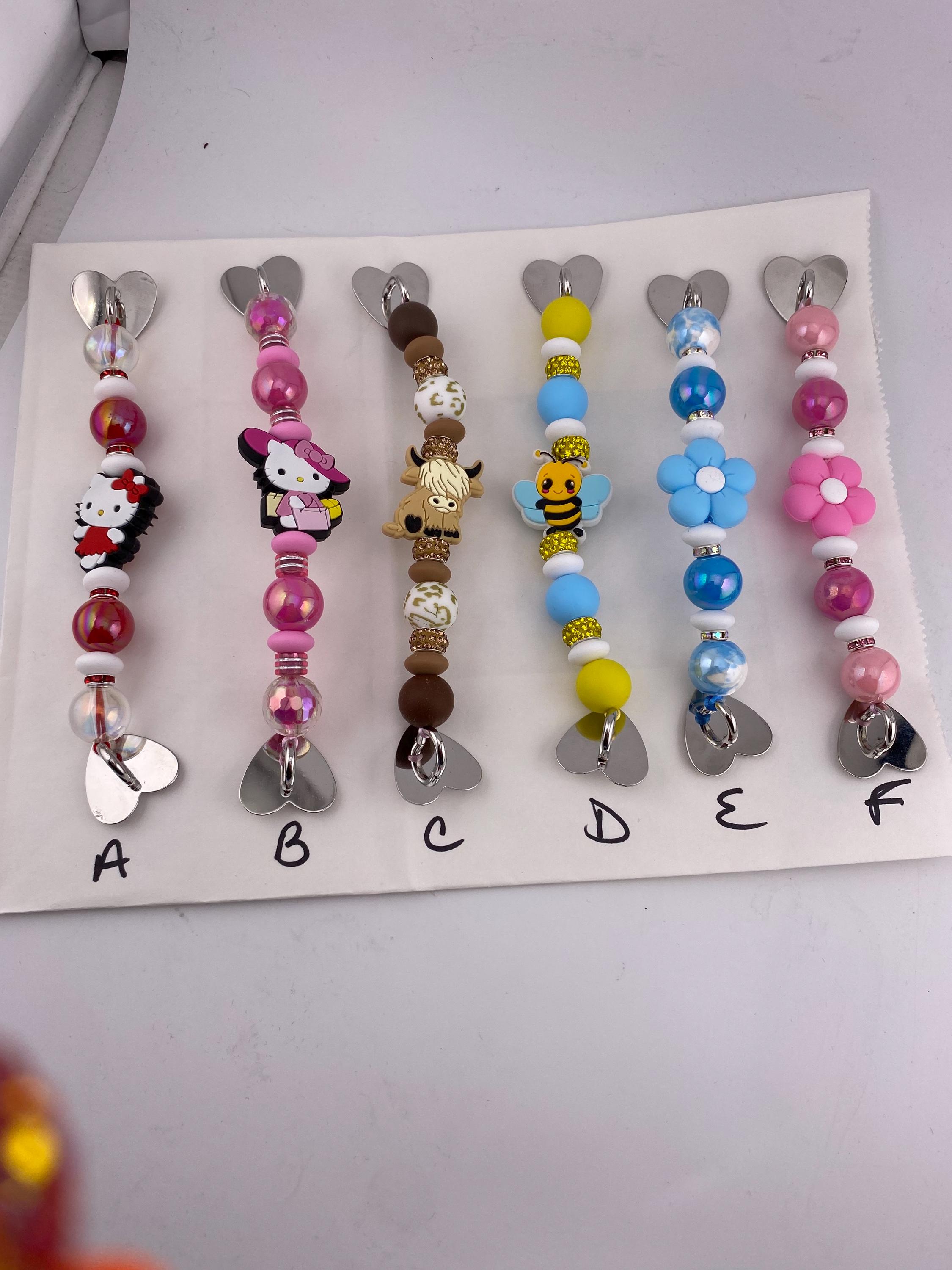 Beaded cell phone, IPad or kindle grip strap holder with various silicone focal bead, heart shaped adhesive grips for back. 7”