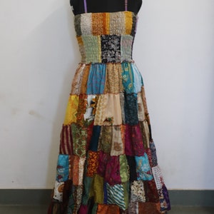Può includere: Un lungo abito patchwork con una varietà di colori e motivi. L'abito è realizzato con diversi tessuti, tra cui seta e cotone. Ha un corpetto aderente e una gonna fluida.