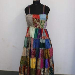 Könnte beinhalten: Ein farbenfrohes Patchwork-Kleid mit einem taillierten Oberteil und einem fließenden Rock. Das Kleid ist aus verschiedenen Stoffen in Rot-, Grün-, Blau-, Lila- und Gelbtönen gefertigt. Das Kleid befindet sich auf einer Schaufensterpuppe.