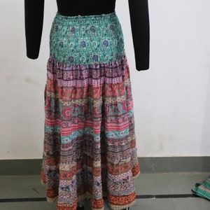 Può includere: Una lunga gonna multicolore con stampa floreale. La gonna ha una combinazione di colori verde, rosa e marrone ed è realizzata in un tessuto morbido e fluido.