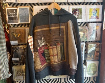 Sudadera gris y marrón con gato sobre libros. Ropa reciclada. Talla M/L.
