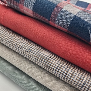 May include: A selection of fabric swatches in a range of colours including red, blue, beige, and grey. The top swatch is a blue and red plaid, followed by a solid red fabric. Other fabrics include a houndstooth pattern and a herringbone weave.