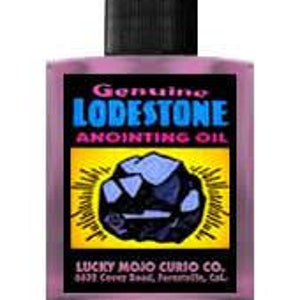 Puede incluir: Una pequeña botella de aceite de unción morado con una tapa negra. La etiqueta dice "Genuine Lodestone Anointing Oil" y "Lucky Mojo Curio Co., 6432 Colby Road, Ferndale, CA".