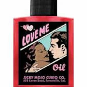 Könnte beinhalten: Eine rote Glasflasche mit schwarzem Verschluss und einem Etikett mit der Aufschrift "Love Me Oil" und einem Cartoon-Bild eines sich küssenden Paares. Auf dem Etikett steht auch "Lucky Mojo Curio Co. 422 Coven Blvd.  Paramount, Cal."