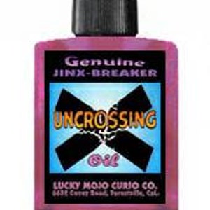 Könnte beinhalten: Eine kleine rosa Flasche mit schwarzem Verschluss, beschriftet mit "Genuine Jinx-Breaker Uncrossing Oil" von Lucky Mojo Curio Co. in weißer Schrift.