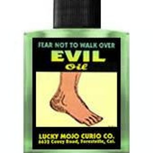 May include: A green glass bottle with a black cap and a yellow label that reads "FEAR NOT TO WALK OVER EVIL oil". The label also features a cartoon illustration of a foot and the text "LUCKY MOJO CURIO CO. 633 CovyRood, Forestal".