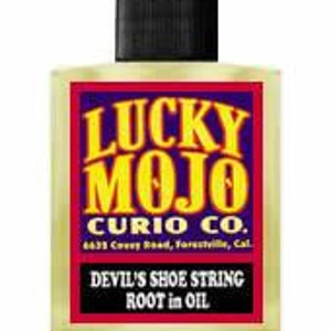 Op de afbeelding: Een glazen fles met een geel etiket waarop staat "LUCKY MOJO CURIO CO. 4635 Covey Road, Forestille, Cal DEVIL'S SHOE STRING ROOT in OIL".