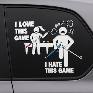 May include: A white vinyl car decal with the text "I LOVE THIS GAME" and "I HATE THIS GAME". The decal features stick figures playing pool, with one figure expressing joy and the other frustration. The background is black.