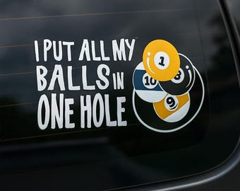 Può includere: Un adesivo in vinile bianco con la scritta "I PUT ALL MY BALLS IN ONE HOLE" e una grafica di diverse palle da biliardo. Le palle da biliardo sono gialle, nere e blu con numeri bianchi.