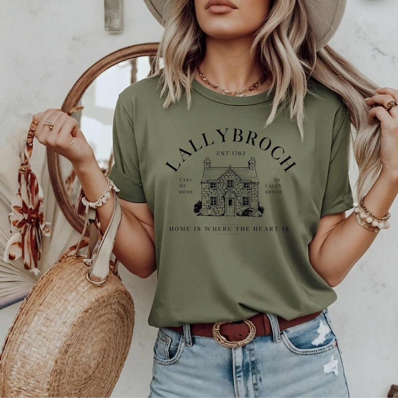 May include: A green t-shirt with a black graphic of a house and the text "Lallybroch Est 1702 Take Me Home To Lallybroch Home Is Where The Heart Is".