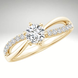 Puede incluir: Un anillo de compromiso de oro con un solo diamante redondo en el centro y diamantes más pequeños engastados en una banda a cada lado.