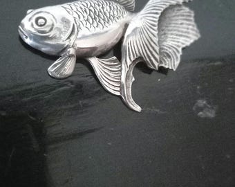 May include: A silver-coloured goldfish figurine with detailed scales and fins. The figurine is a decorative piece with a realistic design.