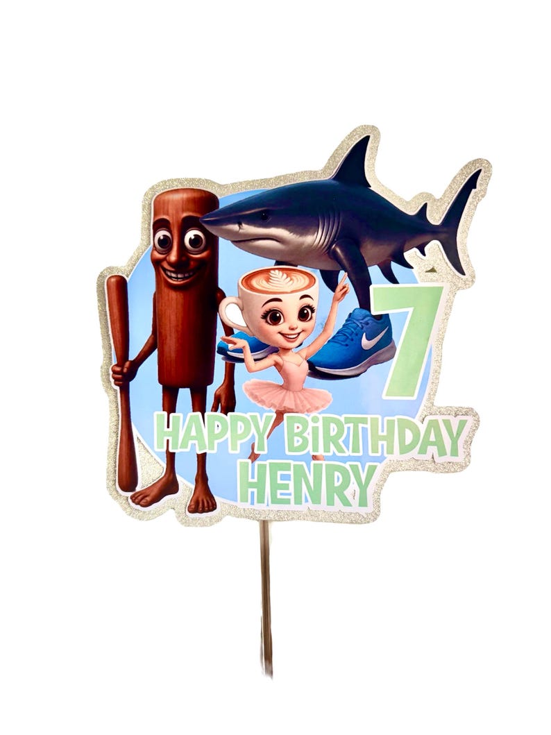 May include: A vibrant birthday cake topper with a cartoon shark, a coffee cup character, and a cinnamon stick figure. The topper includes the text "HAPPY BIRTHDAY HENRY" and the number "7". The design has a glittery border and is mounted on a wooden stick.