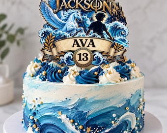 May include: A round cake decorated with blue and white swirled frosting, gold and white sprinkles, and a Percy Jackson themed cake topper featuring a winged horse, a figure with a sword, the name AVA, and the number 13 on a decorative banner.