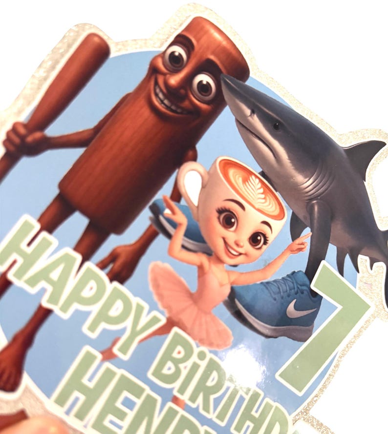 May include: A vibrant birthday cake topper with cartoon characters. Includes a shark, a coffee cup ballerina, and a cinnamon stick with a baseball bat. The text reads "HAPPY BIRTHDAY HENDRI" and the number "7".