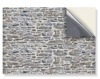 May include: A close-up of a gray stone wall with a rough texture. The wall is made of irregular shaped stones that are stacked on top of each other. The stones are a mix of light and dark gray, and there is some white mortar between the stones.