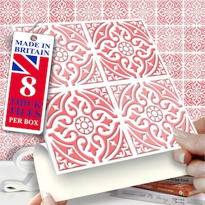 Könnte beinhalten: Acht dicke, rot-weiße Zierfliesen mit einem verzierten floralen Muster. Das Etikett trägt die Aufschrift "Made in Britain". Die Fliesen werden gezeigt, um das Design zu präsentieren. Ideal für dekorative Zwecke.