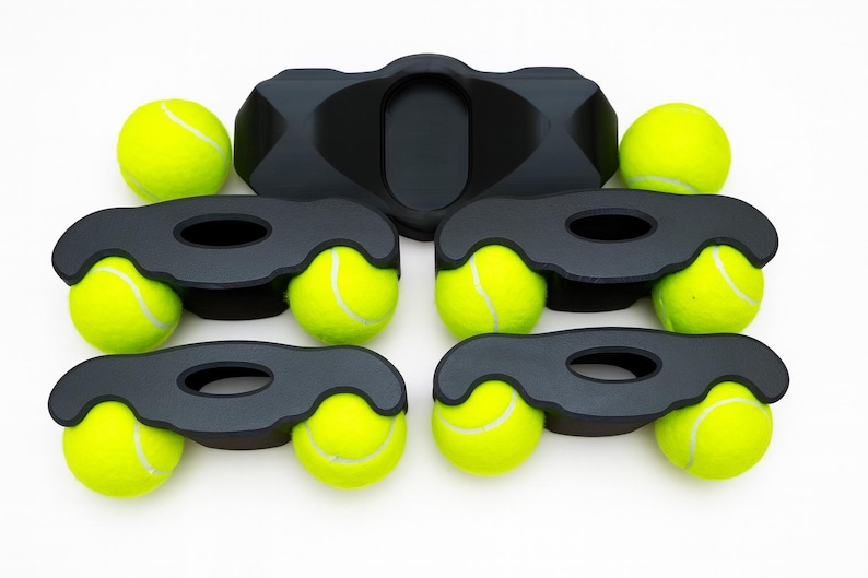 May include: A set of five black plastic furniture leg coasters, each featuring two circular cutouts designed to hold bright yellow tennis balls. The coasters are arranged in a group, with four units holding two tennis balls each and one unit empty.