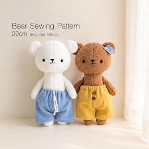 May include: Two handmade bear plushies, one white and one brown, stand side-by-side. The white bear wears blue shorts, and the brown bear wears yellow shorts. The bears are approximately 8 inches tall. Text at the top reads "Bear Sewing Pattern".