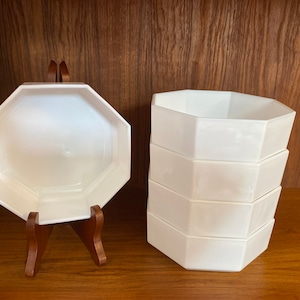 May include: A set of five white octagonal ceramic bowls stacked on top of each other. The bowls are made of a smooth, glossy ceramic and have a simple, elegant design.