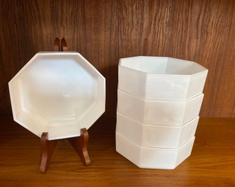 May include: A set of five white octagonal ceramic bowls stacked on top of each other. The bowls are made of a smooth, glossy ceramic and have a simple, elegant design.