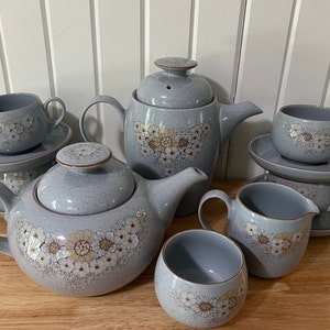 May include: A blue and white floral tea set with a teapot, creamer, sugar bowl, and two teacups and saucers.