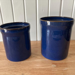 May include: A trio of ceramic mugs with a speckled, matte finish in cream, light grey, and dark grey. Each mug features a simple, minimalist design, ideal for tea or coffee.