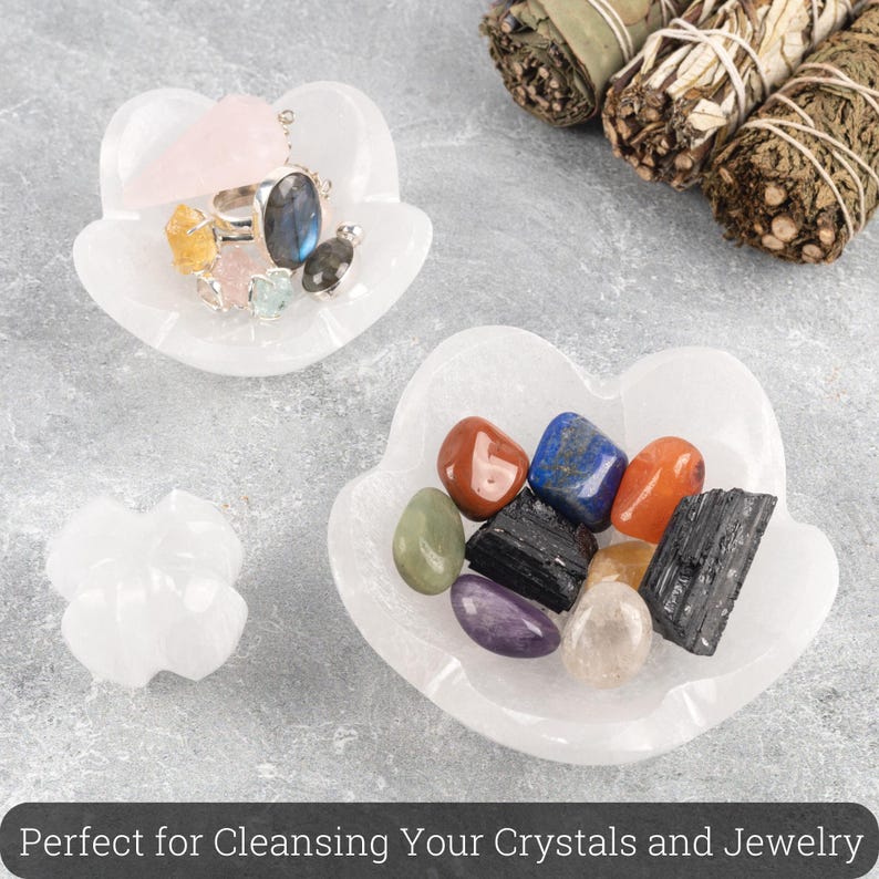 May include: Three white selenite crystal dishes in the shape of a flower. The dishes are filled with various crystals and jewelry. The dishes are perfect for cleansing crystals and jewelry.