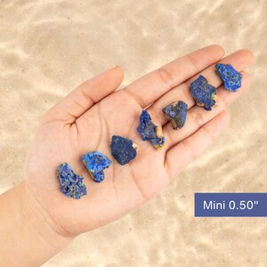 May include: A hand holding six small, rough, blue and yellow azurite stones. The stones are about 0.50 inches in size. Mini 0.50" is written in blue text on a white background.