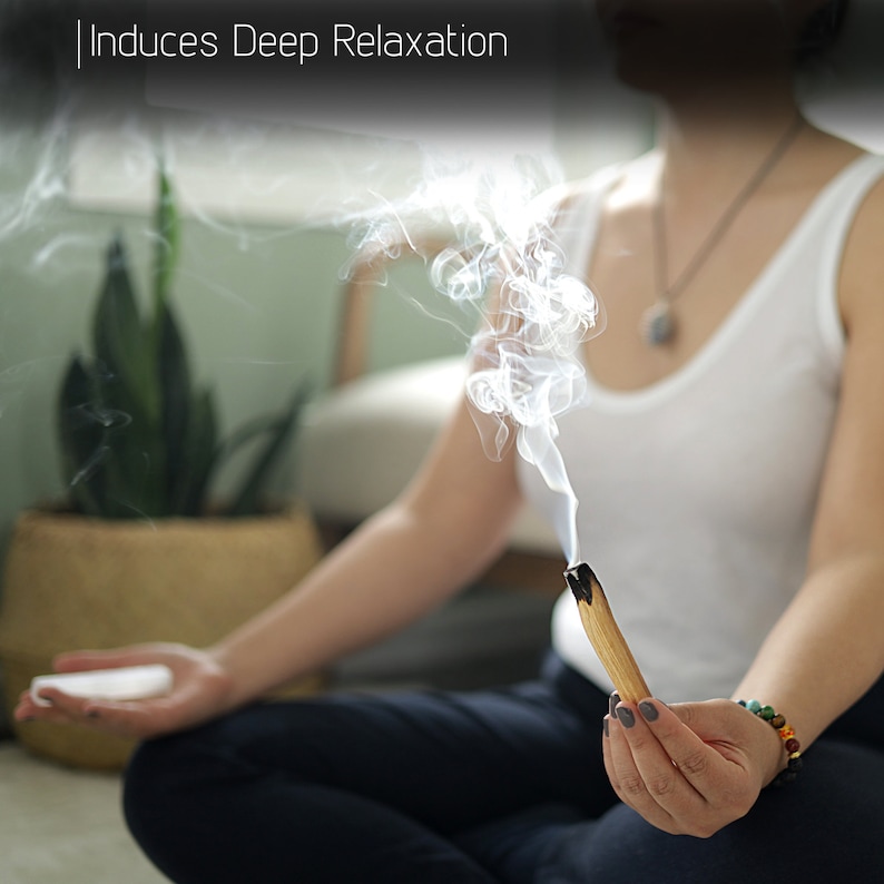 Pu&ograve; includere: Una persona seduta a gambe incrociate sul pavimento, tiene un bastoncino di palo santo fumante, con fumo che sale sopra. Il testo "Induces Deep Relaxation" &egrave; visibile nella parte superiore dell'immagine.