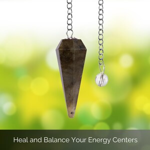 May include: A pendulum with a faceted, dark gray crystal point suspended by a silver chain. A smaller, clear crystal ball hangs from a separate chain. The background is a blurred mix of green and yellow, with the text "Heal and Balance Your Energy Centers".