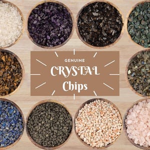 May include: Ten small bowls filled with various types of crystal chips. The bowls are arranged in two rows of five. The bowls are made of wood and have a natural finish. The crystals are all different colors and sizes. The text "GENUINE CRYSTAL Chips" is written in white letters on a brown background.