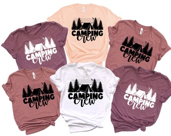 May include: Five t-shirts with the text "Camping Crew" and a graphic of a tent and trees. The shirts are in various colors, including pink, white, and maroon.