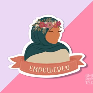 Pu&ograve; includere: Un adesivo con una donna che indossa un velo verde e una corona di fiori. L'adesivo ha uno striscione rosso con la parola "EMPOWERED" su di esso. L'adesivo &egrave; su uno sfondo rosa e viola. Il testo "LITTLE MOON TALES" &egrave; nell'angolo in basso a destra.