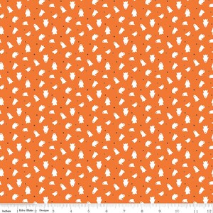 Op de afbeelding: Een levendige oranje stof met een herhalend patroon van kleine witte spookjes en piepkleine zwarte stippen. Een witte liniaal aan de onderkant toont een schaal van 30 cm, wat de grootte en de afstand van de spookmotieven op het textiel aangeeft.