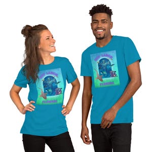 Op de afbeelding: Twee mensen dragen turquoise t-shirts. Elk shirt heeft een afbeelding van een onderwaterwereld met de tekst "Key Largo Florida". De afbeelding bevat een duiker, haaien en ander zeeleven. De shirts hebben korte mouwen.