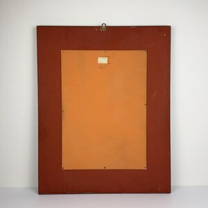 Pu&ograve; includere: Retro di un'opera d'arte incorniciata rettangolare. La cornice &egrave; di colore marrone rossiccio scuro. Il retro dell'opera d'arte &egrave; di colore arancione chiaro. Un piccolo anello di metallo &egrave; attaccato in alto per appenderla. Una piccola etichetta &egrave; apposta sul retro.