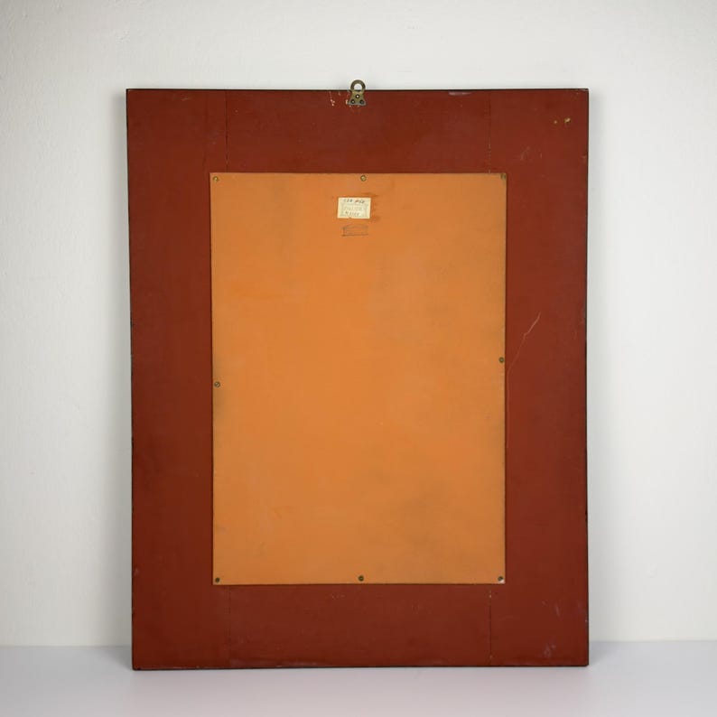 Pu&ograve; includere: Retro di un'opera d'arte incorniciata rettangolare. La cornice &egrave; di colore marrone rossiccio scuro. Il retro dell'opera d'arte &egrave; di colore arancione chiaro. Un piccolo anello di metallo &egrave; attaccato in alto per appenderla. Una piccola etichetta &egrave; apposta sul retro.