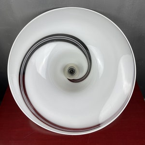 May include: White glass ceiling light fitting with a black spiral design. The light fitting has a white glass shade with a black spiral design.
