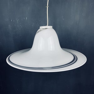 May include: A white ceiling light fitting with a wide, flat, circular base and a bell-shaped shade. The shade has a black and white striped design.