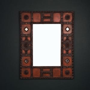 Pu&ograve; includere: Specchio decorativo rettangolare con cornice color rame. La cornice presenta motivi geometrici, accenti floreali e piccoli inserti a specchio. Lo specchio &egrave; progettato per essere appeso a una parete.