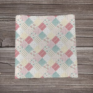 May include: A patchwork fabric with a repeating pattern of pink, yellow, and blue squares with a floral print. The fabric has a white background with a subtle texture.