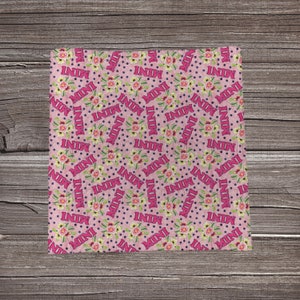 May include: Pink fabric with a repeating pattern of white flowers and the word "MINI" in pink letters. The background is a light pink with small white polka dots.