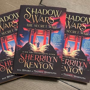 May include: Three copies of the book "Shadow Wars: The Secret War" by Sherrilyn Kenyon with Hinako & Madaug Hishinuma. The cover features a red and black gate with a dark background and a forest in the foreground.