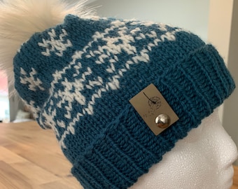 Hand knitted wool hat with snowflakes and brim