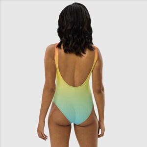 May include: A one-piece swimsuit with a gradient design, transitioning from orange to yellow to green to blue.