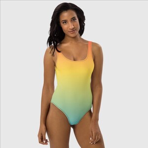 May include: A one-piece swimsuit with a gradient design, transitioning from orange to yellow to green to blue.