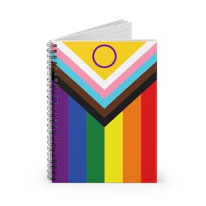 May include: A spiral-bound notebook featuring a colorful design. The cover displays a vibrant pattern with a yellow field and a purple circle, along with stripes in various colors, including pink, blue, brown, and rainbow stripes.